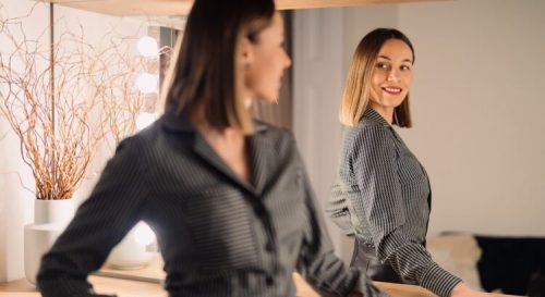 Self-confident,Woman,Looking,At,Her,Reflection,Into,The,Mirror,Indoors.